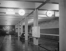 Station Södra Bantorget. Perrrong med klocka, distinationsskyltar och anslagstavla, sedd från söder