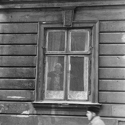 Svartvitt fotografi på fönster i stenfasad.