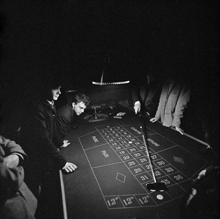 Unga män runt ett spelbord.