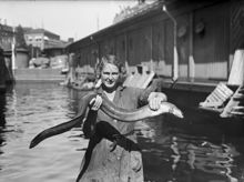 Kvinna håller upp en ål vid fiskhallen vid Munkbron i Gamla Stan.