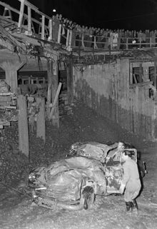 Korsningen Sveavägen-Kungsgatan. En folksamling beskådar demolerad bil, som råkat falla ner i tunnelbanebygget