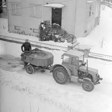 Traktor med släpvagn fylld med sand för sandning
