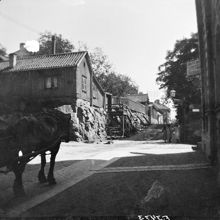 Bergsgatan österut från hörnet av Parmmätargatan.Till vänster Bergsgatan 14, 12 och 10 i kvarteret Bergsklippan Större.En häst är på väg uppför backen.  