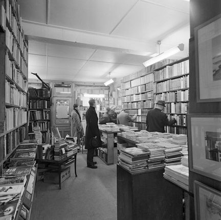 Antikvariatsinteriör med flera kunder.