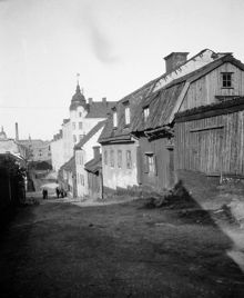 Bengt Ekehjelmsgatan österut. T.h. ligger Bengt Ekehjelmsgatan 17 - 9. Några personer står vid korsningen av Timmermansgatan. Timmermansgatan 39 (med hörntornet) byggdes 1906. Nu kv. Hållkarlen