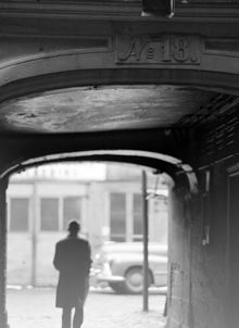 Beridarbansgatan 18. En man passerar portgången från gatan mot gården