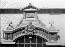 Hötorgshallen före rivningen 1954. Byggnadsdetaljer vid taket med årtalet 1882 då saluhallen byggdes och vapensköld med St. Erik