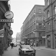 Regeringsgatan 57-59 söderut vid hörnet av Jakobsbergsgatan 29. I förgrunden en ny Ford Mustang.