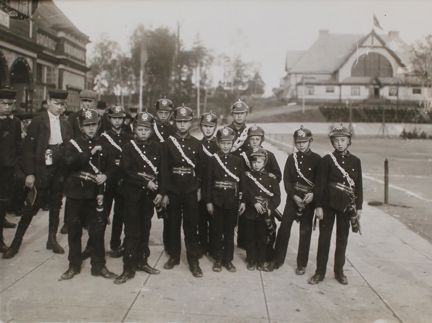 En grupp pojkar med branduniformer och hjälmar.