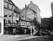 Några män och barn på Nybergs Gränd. Sänkning av gatunivån pågår vid Nybergs Gränd 8-2 söderut mot Linnégatan 48. Dåvarande kv. Kronkvarnen. Nuvarande Nybergsgatan, kv. Grannarne