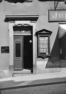 Porten till fastigheten vid Götgatan 3. Till höger om porten syns ett skyltskåp med bilder tagna av fotograf Mimmi Gustafssons som har sin fotografi ateljé i huset.
