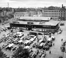Hötorget och Hötorgshallen söderut. T.v. är kv. Grytgjutaren rivet men Betlehemskyrkan är ännu kvar. Bakom saluhallen är Nya Elementarskolan riven. Kvar är Konstfackskolan med lanterninen