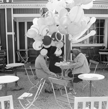 Ballongförsäljerska tar kaffepaus på ett utecafé