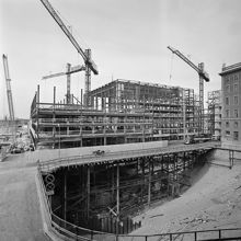 Brunkebergstorg, nordvästra delen. Brunkebergstorg 7-9 och Beridarbansgatan 1-5 byggs. T.h. är Telestyrelsens hus, där kommer Riksbanken att byggas. T.v. Vattugatan västerut