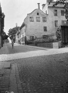 En pojke går Bastugatan västerut från hörnet av Blecktornsgränd. T.h. Bastugatan 22, 24 och 26. Då kv. Kattfoten Större, nu kv. Kattörat. Vid träden t.h. i fonden ligger idag Ivar Los Park