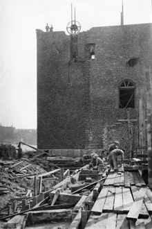 Stadshustornet under uppbyggnad, östra fasaden. Murare och timmermän i arbete.