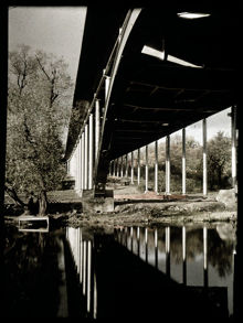 Västerbron, bropelarna speglar sig i vattnet vid Pålsundet.