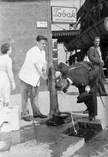 Hötorget. Glassförsäljaren Rune Svensson hjälper polismannen Roland Lannerström att dricka ur vattenpump
