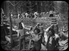 Tegelbärare och murare i arbete vid Stadshusbygget i juli 1916