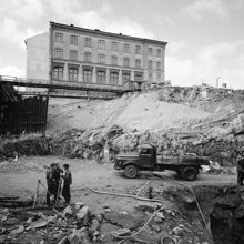 Schaktning i kv. Faunen och kv. Stigbygeln. Sergelgatan går på en provisorisk träbro. Vy västerut mot Konstfackskolan under rivning, fasaden mot Sergelgatan