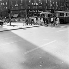 Sveavägen vid korsningen med Kungsgatan. I bakgrunden kv. Hästhuvudet. Fotgängare passerar på övergångsstället