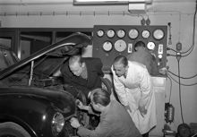 Bergengren AB, bilteknisk provningsanstalt. Män står vid en öppen motorhuv och mekar