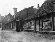 Lilla Badstugatan 13 och 11. En sotare står på en skorsten på taket