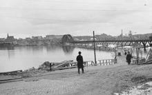 Vy västerut från Lidingö mot nya Lidingöbron under byggnad. I fonden Hjorthagen och Värtagasverket.