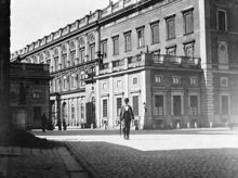 Kungliga slottets västra fasad. En manlig flanör i förgrunden