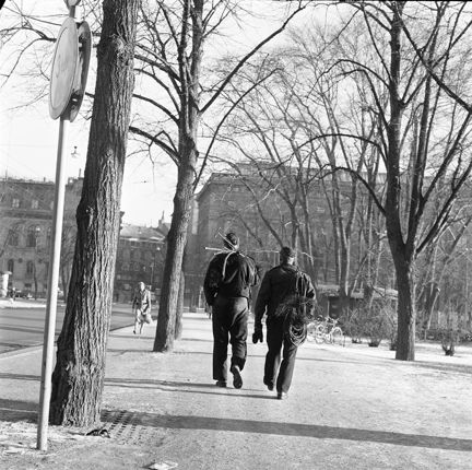 Två sotare promenerar, fotograferade bakifrån.