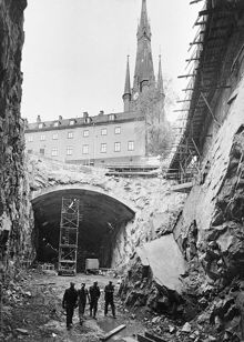 Tunnelbanan byggs. Vy från Vasagatan 22 österut genom rivna kv. Kajan, nu Orgelpipan 6. I fonden ligger Klara Västra Kyrkogata 20 och Klara kyrkas torn