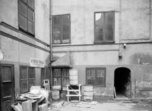 Mäster Samuelsgatan 45. Gårdens nordvästra hörn. Tunnor och lådor vid Nordiska Fröhandelns lokaler. Portgång mot Mäster Samuelsgatan. Nu står femte höghuset här