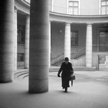 En dam går över gården vid Kanslihuset, Mynttorget 2
