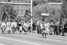Reportage kring Kungabröllopet den 19 juni 1976. Fanbärare i folkdräkt tågar över Norrbro, främst går en man med skylten ""Mora kompani""