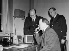 Huddinge Polisstation. Premiär för polisradio hos Huddingepolisen. Polischef Sven Wadenius provar utrustningen. Kommissarie Gösta Rohlin och överkonstapel K.E Haglund ser på
