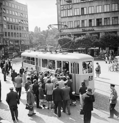 Människor köar för att gå ombord en spårvagn