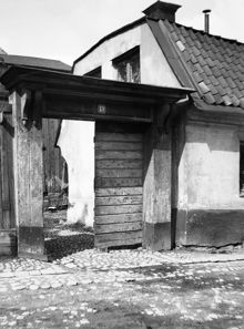 Port i planket mot kullerstensbelagda gården vid Lilla Bastugatan 19. Här ligger idag parken söder om Stadsbiblioteket vid Sveavägen