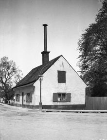 Långholmsgatan 1. Några barn står vid räcket till Långholmsbron till vänster om huset. Dåvarande kv. Långholmsbron 10, nu parkområde
