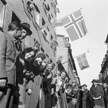 Fredsdagen den 7:e maj 1945. 
Flaggviftande människor firar freden längs Mäster Samuelsgatan.