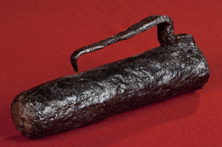 En krutkammare av järn med handtag och träplugg