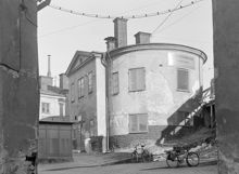 Kv. Järngraven Övra. Byggnadens västra sida. Södra sidan t.h. är Södermalmstorg 26. Vy från Brännkyrkagatan 1, nuvarande Guldgränd
