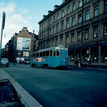 Sibyllegatan och kv. Sjökalven sedda från Östermalmstorg. 8:ans spårvagn på väg söderut. Fasadreklam för Electrolux diskmaskiner på rivningstomt mitt i kvarteret