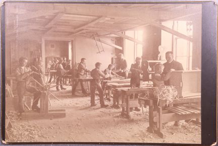 Svartvitt fotografi på pojkar vid slöjdlektion på uppfostringsanstalten Åkerbrukskolonin Hall