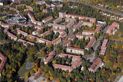 Huskroppar med blekröda tak och träd emellan.