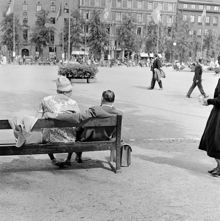 Kungsträdgården mot öster, Kungsträdgårdsgatan. I förgrunden ett äldre par på parkbänk