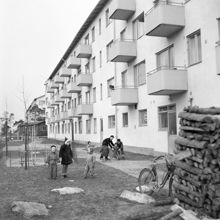 Johanneshov. Nybyggda flerfamiljshus. Lekande barn på husets baksida