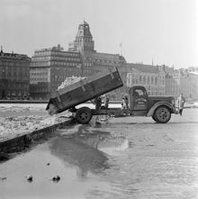 Snötippning i Nybroviken från Strandvägen. Strand Hotell i bakgrunden