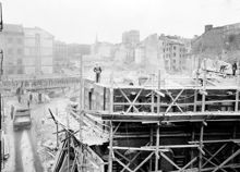 Vy norrut över rivningen av Hamngatan 38 i kvarteret Hoven. En lastbil står på Beridarbansgatan. Till vänster ligger Konstfackskolan vid Mäster Samuelsgatan 44 och i fonden syns Kungstornen.