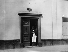 En man står i porten till Götgatan 76 A. Nuvarande Götgatan 138. I kvarteret ligger nu Åhléns varuhus på Södermalm