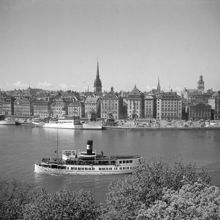 En ångbåt på Strömmen med Skeppsbron och Gamla Stan i fonden. Vy norrut från Skeppsholmen